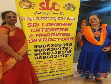 Sri Lakshmi Caterers staff beside the company banner at an event venue