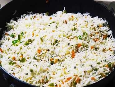 Vegetable pulao cooked in a bulk kadai for economical event catering