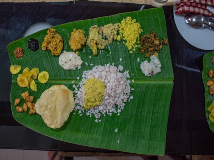 Traditional Kerala meal laid out on a banana leaf for guests
