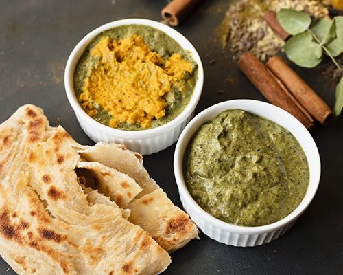 Naan served with dal and palak paneer bowls at a North Indian counter
