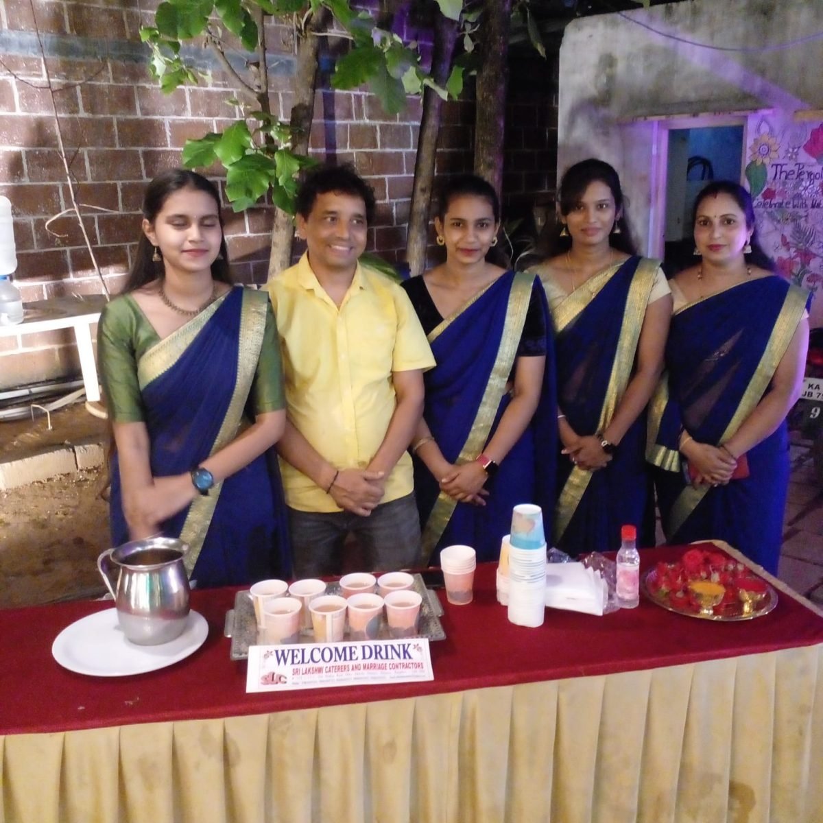 Hostesses serving welcome drinks to arriving guests at a catered event