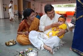 Baby being fed the first spoon of rice during an annaprasana ceremony