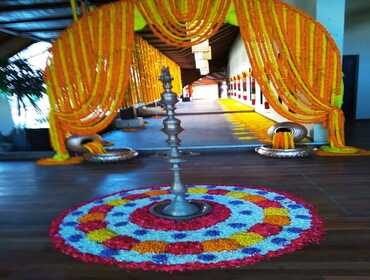 Wedding mandap framed with floral decoration and a rangoli floor